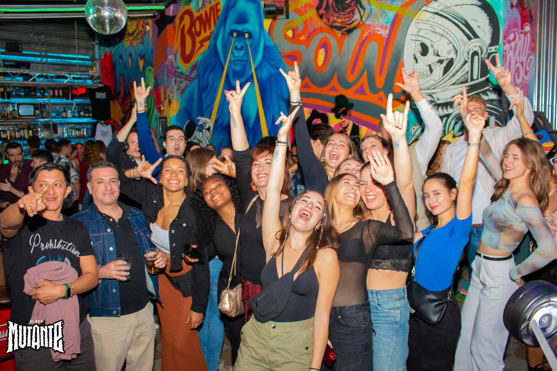 Friends smiling and celebrating together in a colourful Seville venue